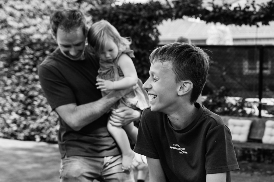 Familie in de achtertuin lachend tijdens een gezinsshoot in Boxmeer.