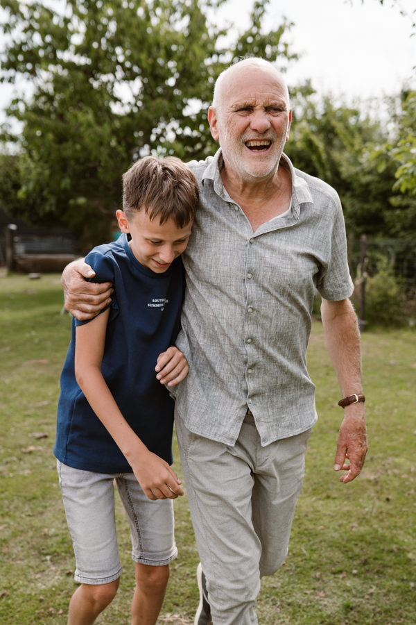 Opa en kleinzoon lopen samen door de tuin tijdens de familieshoot in het Land van Cuijk