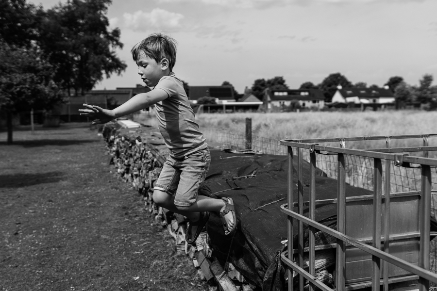 Kind springt van een hek af tijdens een gezinsshoot in Boxmeer.