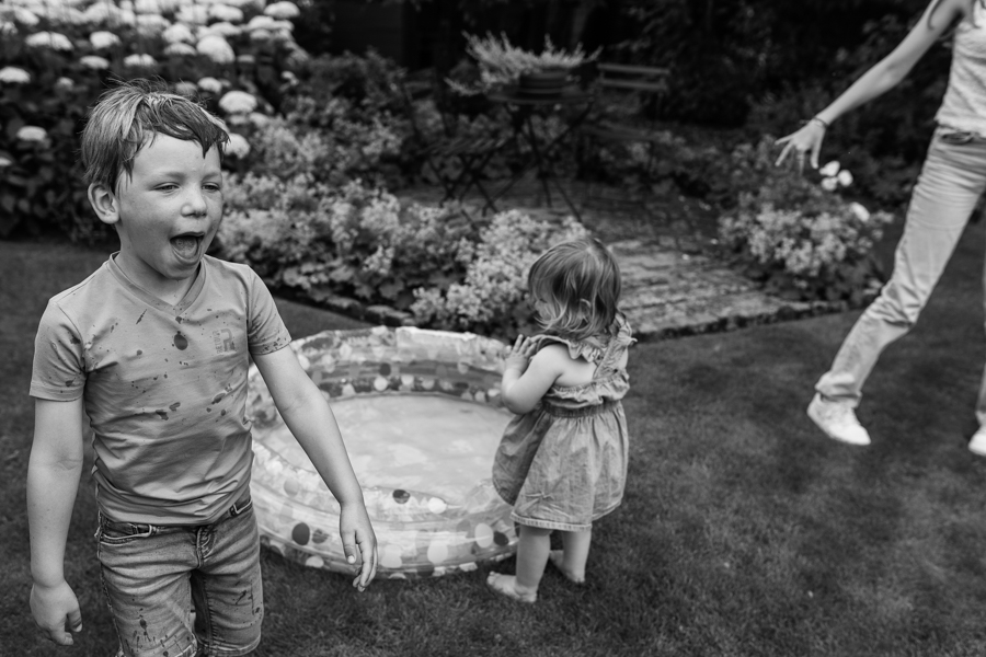 Familie ontspant in de tuin met zwembadje tijdens de familieshoot