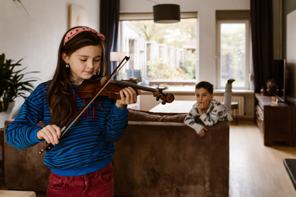 Kind speelt viool voor haar mama tijdens een gezinsshoot in Land van Cuijk.