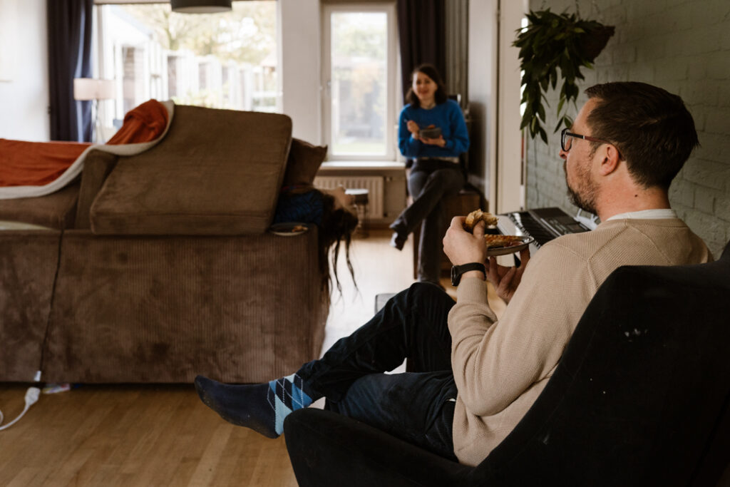 Ouders kijken toe terwijl kinderen spelen tijdens gezinsfotografie Land van Cuijk