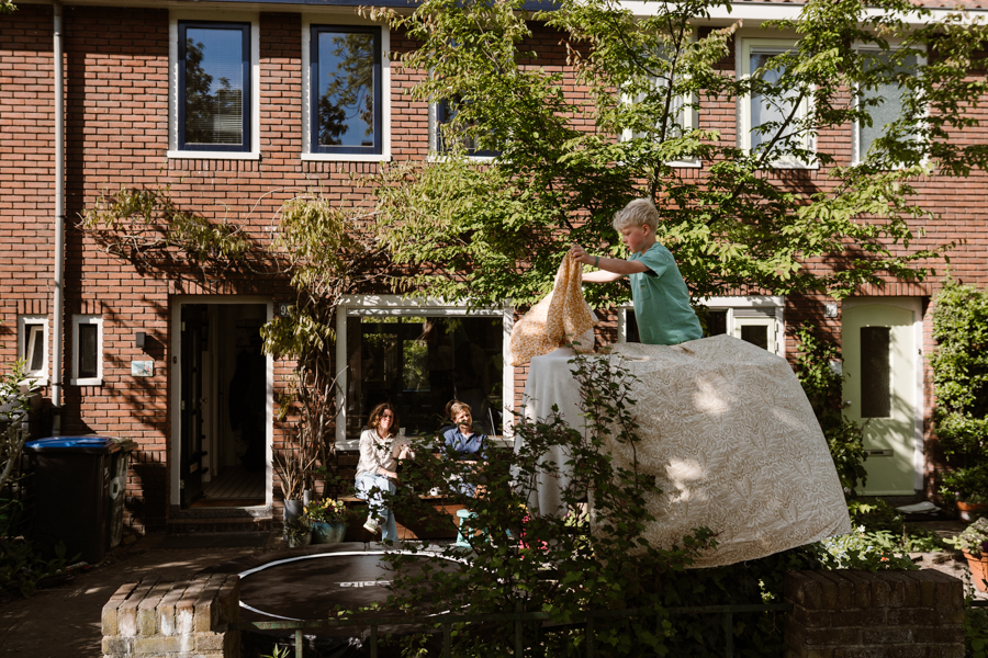 Samen in de voortuin spelen tijdens een documentaire gezins fotoshoot in Nijmegen